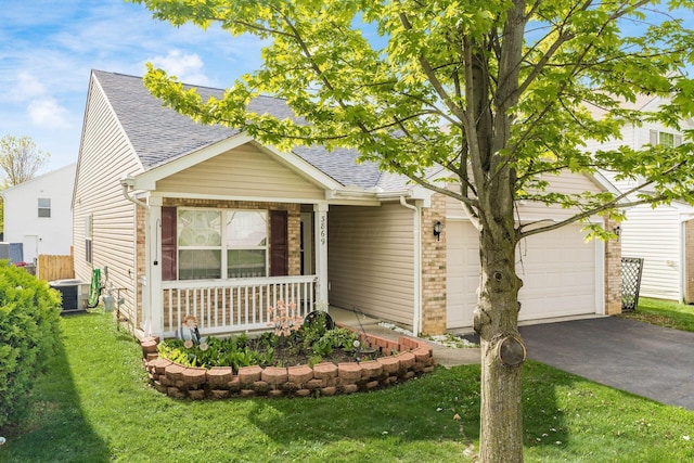 view of front of property featuring roof with shingles, a garage, a porch, driveway, and a front yard