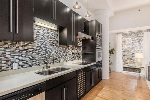 106 N High St Unit 504, Columbus, OH 43215 - kitchen featuring a sink, under cabinet range hood, stainless steel appliances, beverage cooler, and tasteful backsplash