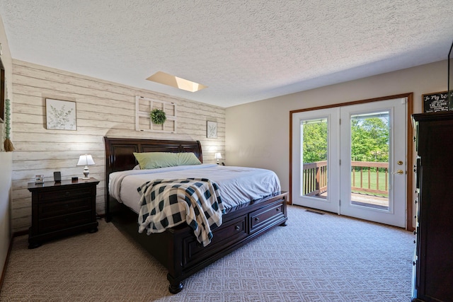 7684 Stout Rd, Circleville, OH 43113 - carpeted bedroom featuring wood walls, a skylight, a textured ceiling, and access to exterior