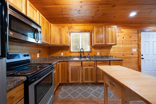 34047 W Buckingham Rd, Logan, OH 43138 - kitchen with stainless steel appliances, a sink, wood ceiling, dark wood-type flooring, and wood walls