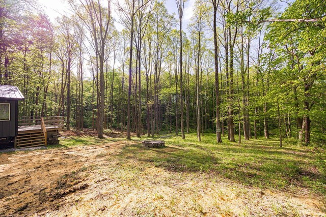 34047 W Buckingham Rd, Logan, OH 43138 - view of yard featuring a wooden deck, a fire pit, and a view of trees