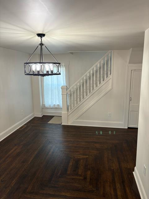 125 College St, Urbana, OH 43078 - unfurnished dining area with a chandelier, stairs, and baseboards