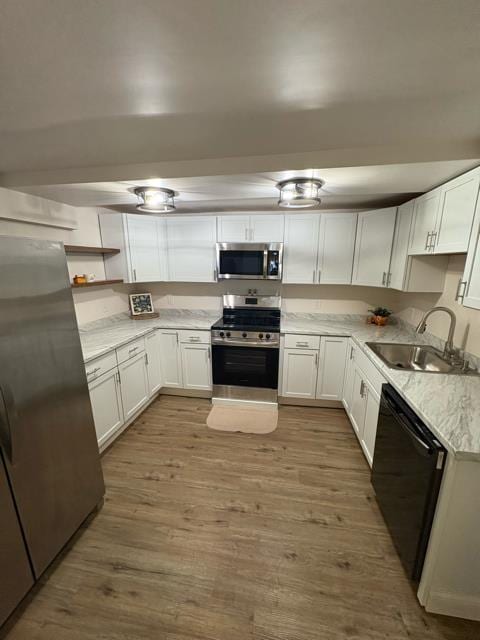 125 College St, Urbana, OH 43078 - kitchen with stainless steel appliances, a sink, white cabinets, light wood-type flooring, and open shelves