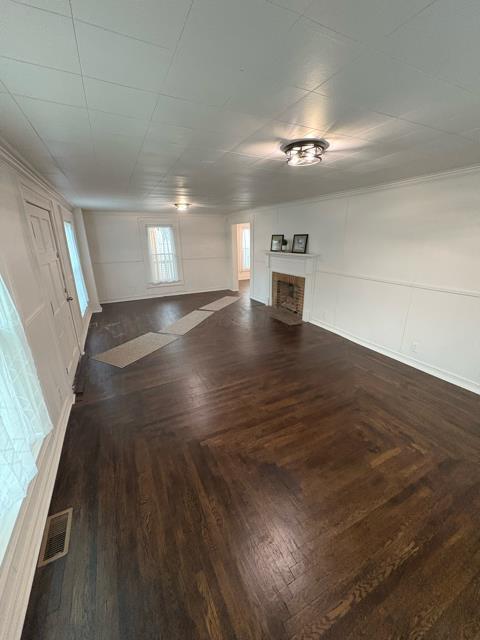 125 College St, Urbana, OH 43078 - unfurnished living room with a fireplace with flush hearth and dark wood-style flooring