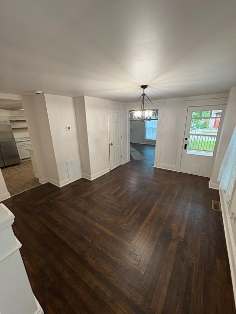 125 College St, Urbana, OH 43078 - unfurnished dining area featuring a chandelier, baseboards, and parquet floors
