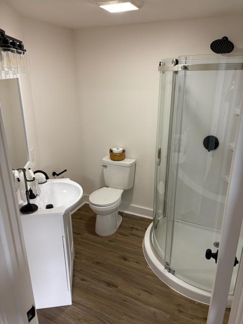 125 College St, Urbana, OH 43078 - bathroom featuring a stall shower, wood finished floors, vanity, toilet, and baseboards
