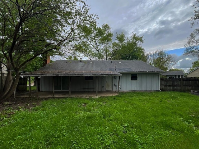 back of property featuring a patio area, a chimney, and board and batten siding