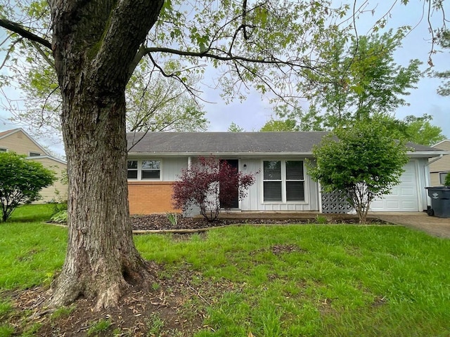 view of front of house featuring a garage, brick siding, a front lawn, board and batten siding, and driveway