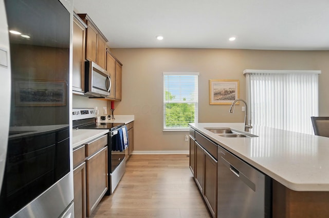 4410 Holstein Dr, Columbus, OH 43207 - kitchen featuring appliances with stainless steel finishes, a sink, light wood-style floors, a kitchen island with sink, and recessed lighting
