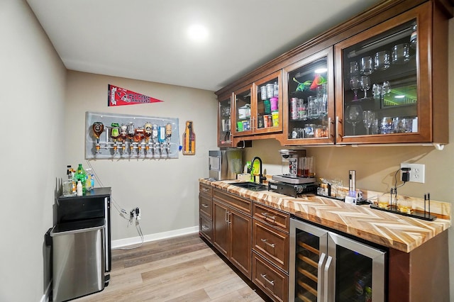 4410 Holstein Dr, Columbus, OH 43207 - indoor wet bar with beverage cooler, light wood-type flooring, and baseboards