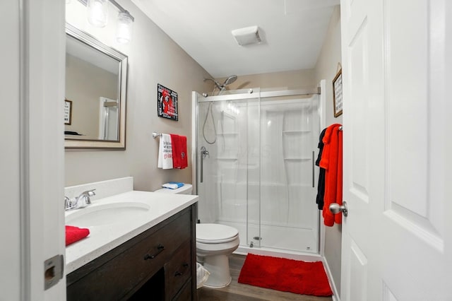 4410 Holstein Dr, Columbus, OH 43207 - bathroom with a stall shower, toilet, vanity, and wood finished floors