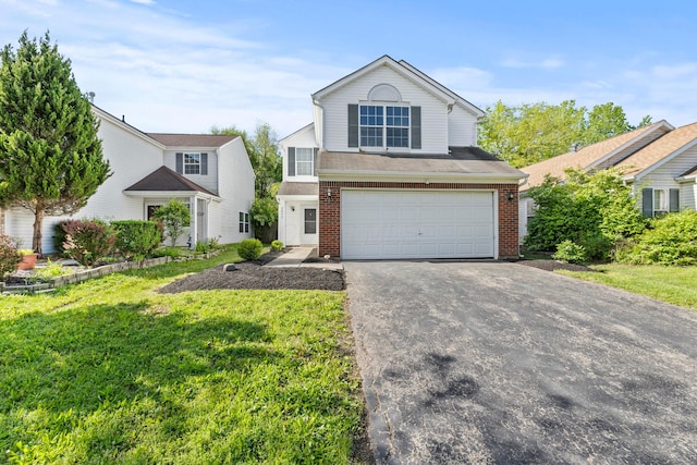 traditional-style home featuring a garage, brick siding, driveway, and a front yard