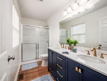 592 Summer Tree Loop, Marysville, OH 43040 - bathroom with a shower stall, wood finished floors, double vanity, and toilet