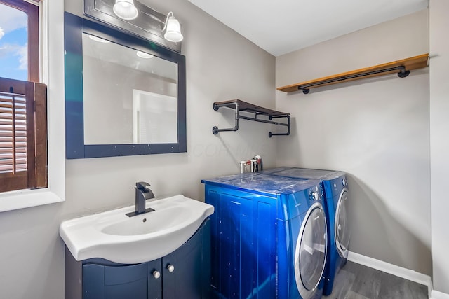 229 Pennsylvania Ave, Marion, OH 43302 - laundry area featuring washing machine and dryer, wood finished floors, baseboards, and a sink