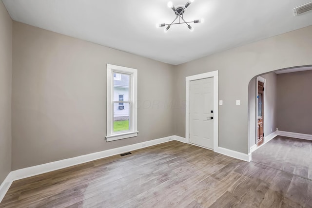 229 Pennsylvania Ave, Marion, OH 43302 - foyer with arched walkways, a chandelier, wood finished floors, and baseboards