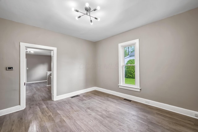 229 Pennsylvania Ave, Marion, OH 43302 - empty room with wood finished floors, a chandelier, and baseboards