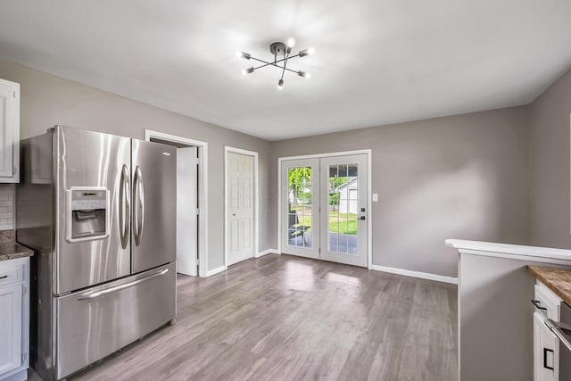 229 Pennsylvania Ave, Marion, OH 43302 - kitchen with stainless steel refrigerator with ice dispenser, a chandelier, light wood finished floors, and baseboards