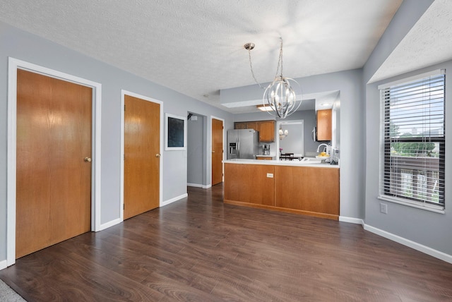 5524 Rushden Dr, Columbus, OH 43230 - kitchen with stainless steel refrigerator with ice dispenser, a chandelier, brown cabinetry, dark wood-style floors, and a textured ceiling