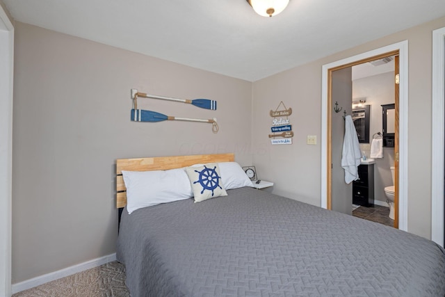 bedroom with ensuite bath and baseboards