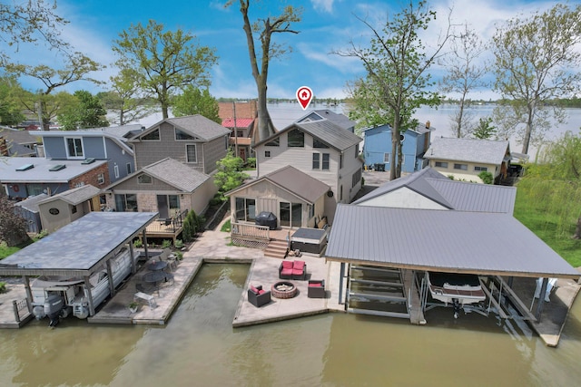 dock featuring boat lift, a water view, and a residential view