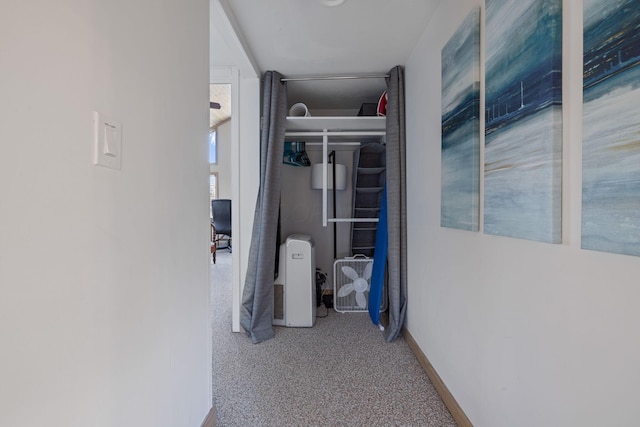 corridor with baseboards and carpet