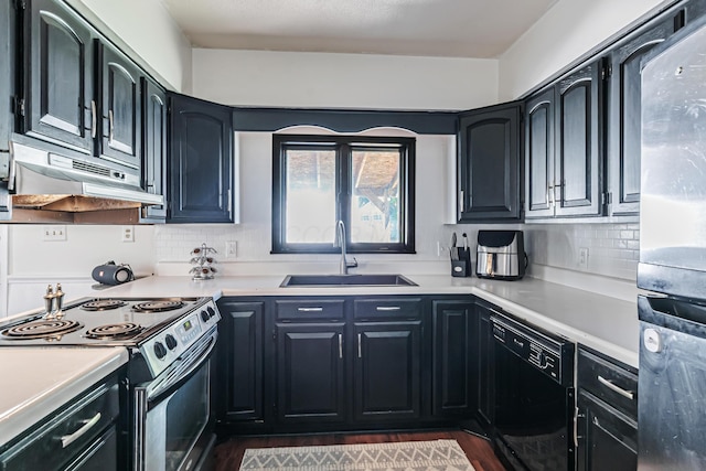 76 Resch St, Kenton, OH 43326 - kitchen featuring a sink, under cabinet range hood, appliances with stainless steel finishes, backsplash, and dark wood finished floors