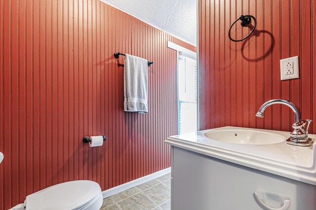 76 Resch St, Kenton, OH 43326 - bathroom featuring toilet, vanity, a textured ceiling, and wood walls