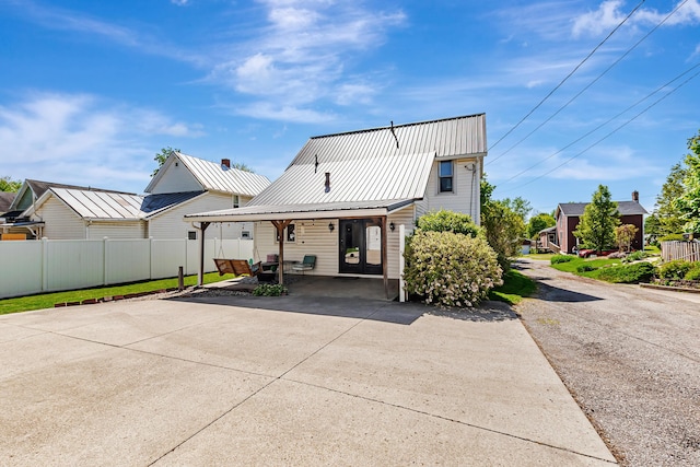 76 Resch St, Kenton, OH 43326 - view of front facade with fence, a patio, metal roof, and concrete driveway