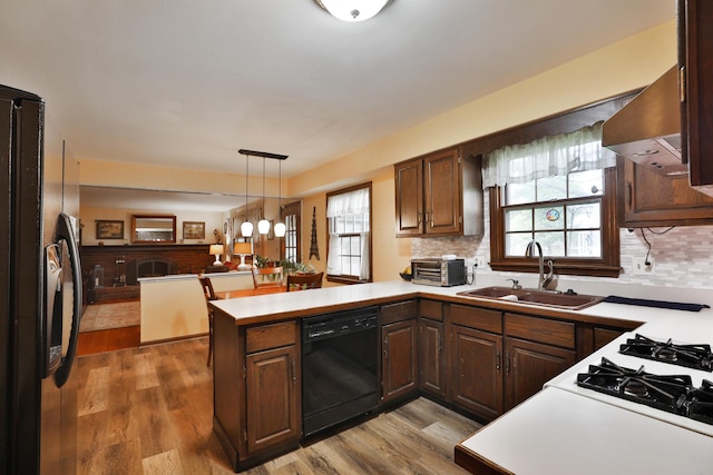 1262 Pepperell Dr, Columbus, OH 43235 - kitchen featuring black appliances, a peninsula, a sink, wall chimney exhaust hood, and decorative backsplash