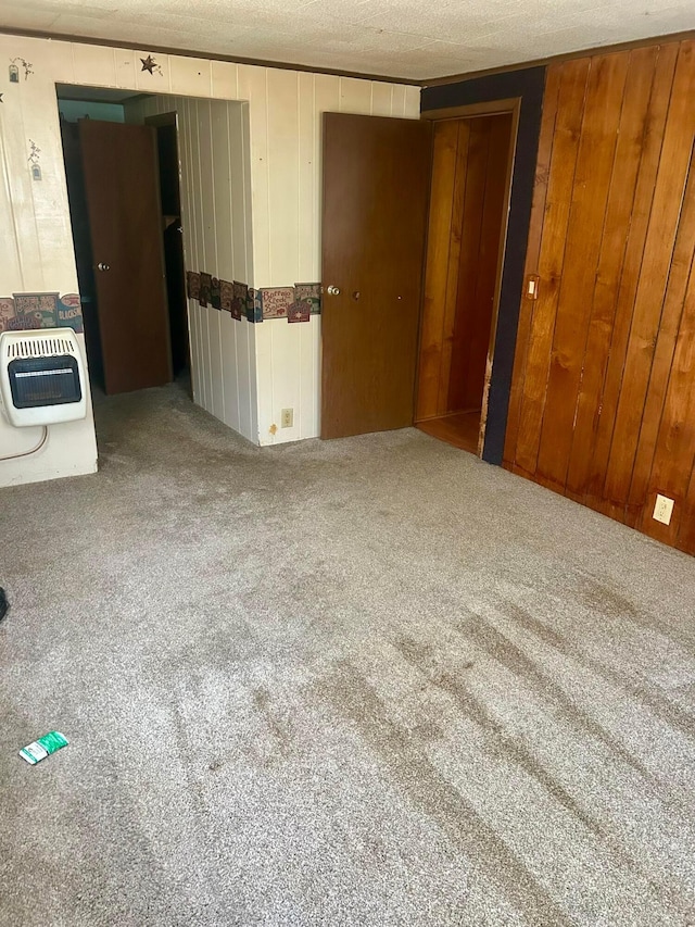 3617 Waugh Rd, Frankfort, OH 45628 - carpeted empty room featuring heating unit, wooden walls, and a textured ceiling