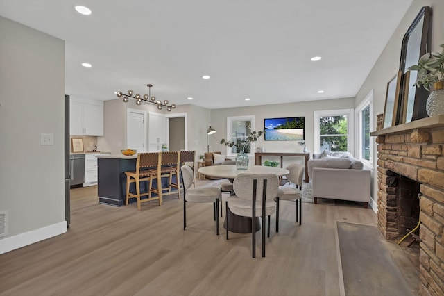 2095 Mccoy Rd, Upper Arlington, OH 43220 - dining room featuring light wood-style flooring, recessed lighting, a stone fireplace, and baseboards