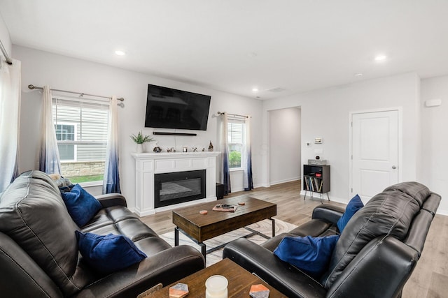 6355 Marinelli Dr N, Columbus, OH 43228 - living room with light wood-type flooring, recessed lighting, a glass covered fireplace, and baseboards