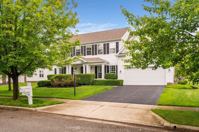 5073 Thornwood Dr, Westerville, OH 43082 - colonial-style house featuring driveway, a front yard, roof with shingles, and a garage