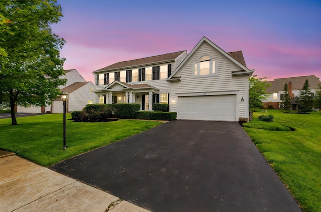 5073 Thornwood Dr, Westerville, OH 43082 - view of front of house with a garage, asphalt driveway, and a lawn