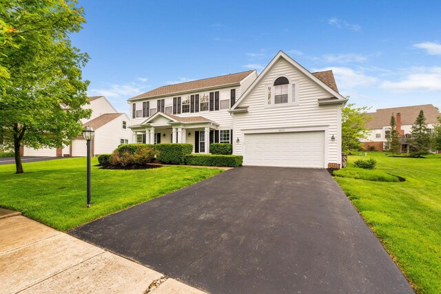 5073 Thornwood Dr, Westerville, OH 43082 - traditional-style house with an attached garage, asphalt driveway, a front lawn, and roof with shingles