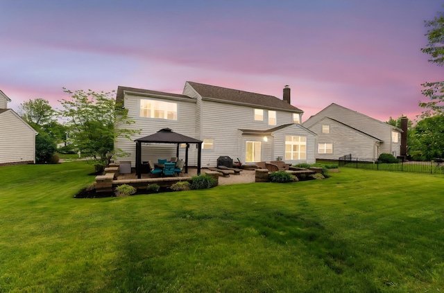 5073 Thornwood Dr, Westerville, OH 43082 - back of house at dusk with a gazebo, a chimney, an outdoor living space, and a patio