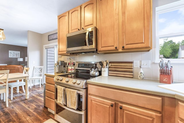5073 Thornwood Dr, Westerville, OH 43082 - kitchen featuring stainless steel appliances, decorative backsplash, dark wood-type flooring, and light countertops