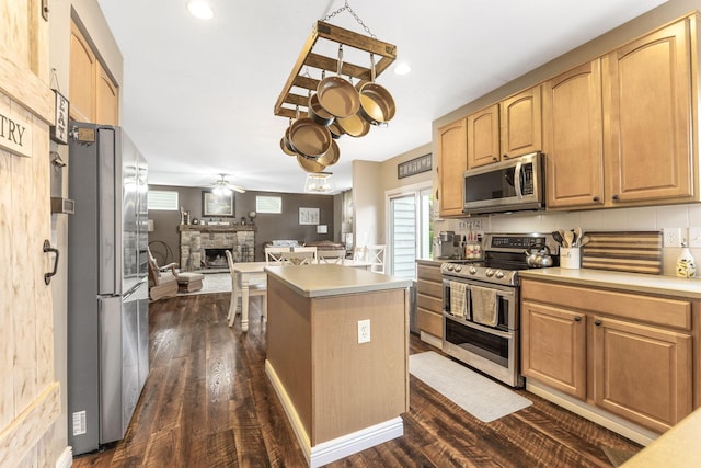 5073 Thornwood Dr, Westerville, OH 43082 - kitchen with appliances with stainless steel finishes, a ceiling fan, open floor plan, dark wood-style floors, and a center island