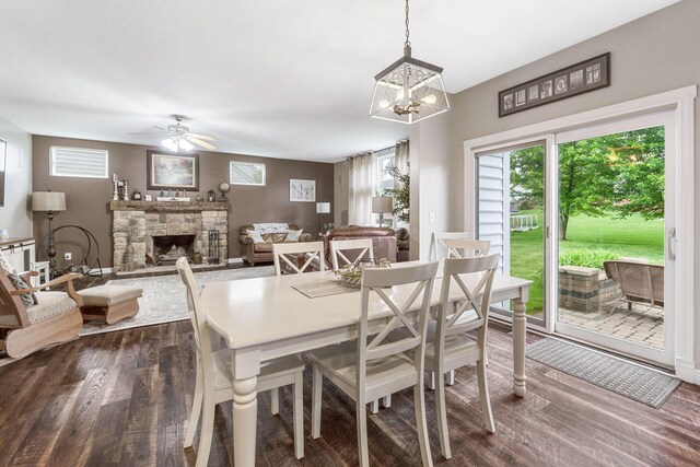 5073 Thornwood Dr, Westerville, OH 43082 - dining room featuring dark wood-style flooring, a fireplace, ceiling fan, and a chandelier