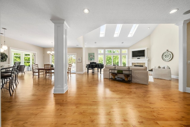 504 W Orange Rd, Delaware, OH 43015 - living room featuring light wood-type flooring, a fireplace, a chandelier, decorative columns, and recessed lighting