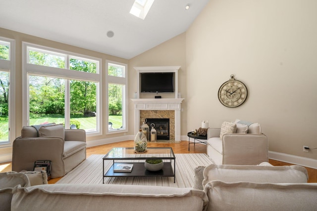 504 W Orange Rd, Delaware, OH 43015 - living room with a fireplace, baseboards, wood finished floors, high vaulted ceiling, and a skylight