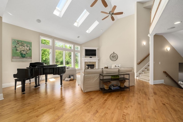 504 W Orange Rd, Delaware, OH 43015 - living area with a fireplace, high vaulted ceiling, light wood-style floors, a ceiling fan, and a skylight