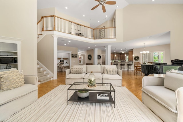 504 W Orange Rd, Delaware, OH 43015 - living area featuring ceiling fan, decorative columns, wood finished floors, high vaulted ceiling, and a chandelier