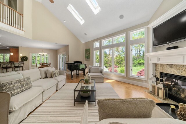 504 W Orange Rd, Delaware, OH 43015 - living area featuring a premium fireplace, high vaulted ceiling, wood finished floors, a chandelier, and a skylight
