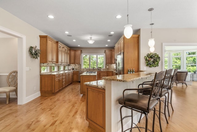 504 W Orange Rd, Delaware, OH 43015 - kitchen with brown cabinetry, light wood-type flooring, fridge, light stone counters, and recessed lighting