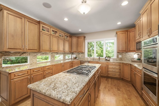 504 W Orange Rd, Delaware, OH 43015 - kitchen with appliances with stainless steel finishes, light wood-style floors, backsplash, light stone countertops, and recessed lighting