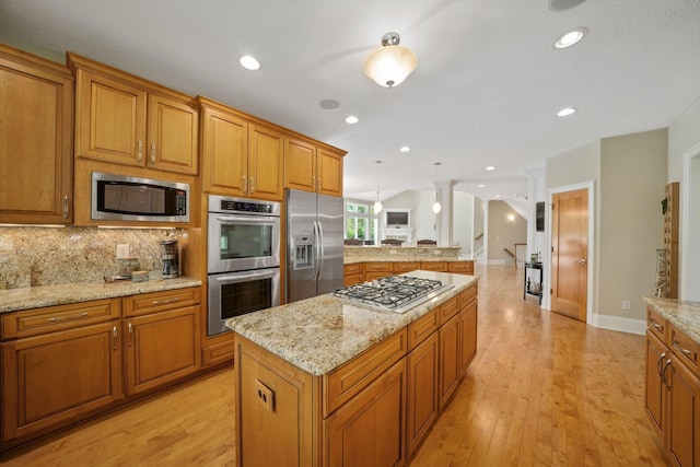 504 W Orange Rd, Delaware, OH 43015 - kitchen with stainless steel appliances, brown cabinets, light wood finished floors, lofted ceiling, and recessed lighting