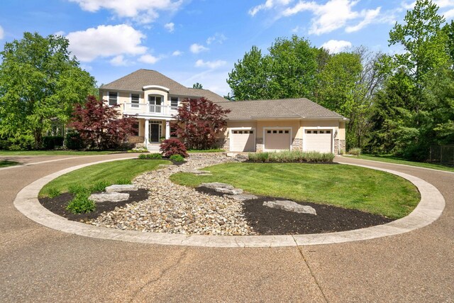 504 W Orange Rd, Delaware, OH 43015 - view of front of property featuring an attached garage, a front yard, a balcony, concrete driveway, and stone siding