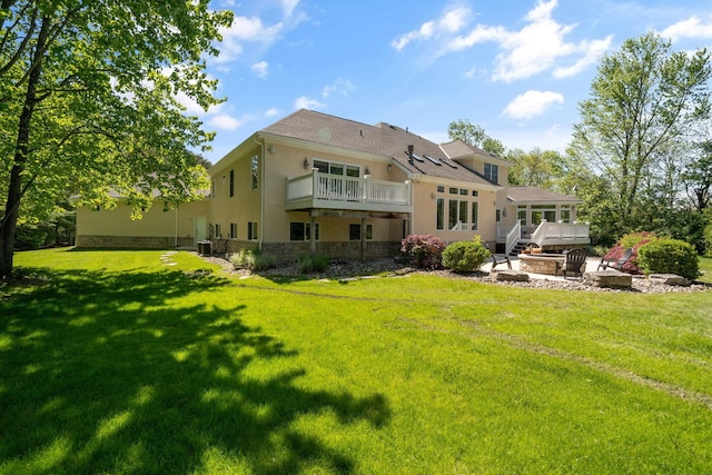 504 W Orange Rd, Delaware, OH 43015 - rear view of house with stucco siding, a yard, stone siding, and a wooden deck
