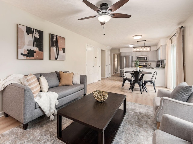 1520 Dickson Dr, Columbus, OH 43228 - living room with light wood-style flooring, a ceiling fan, rail lighting, and a textured ceiling